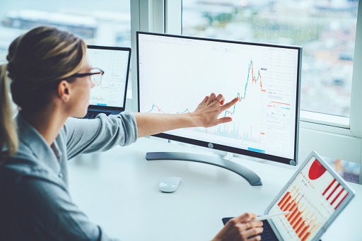 Lady comparing graphs on computer